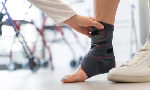 Close-up of a woman’s foot with a sports ankle brace Close-up of a woman's foot with a sports ankle brace